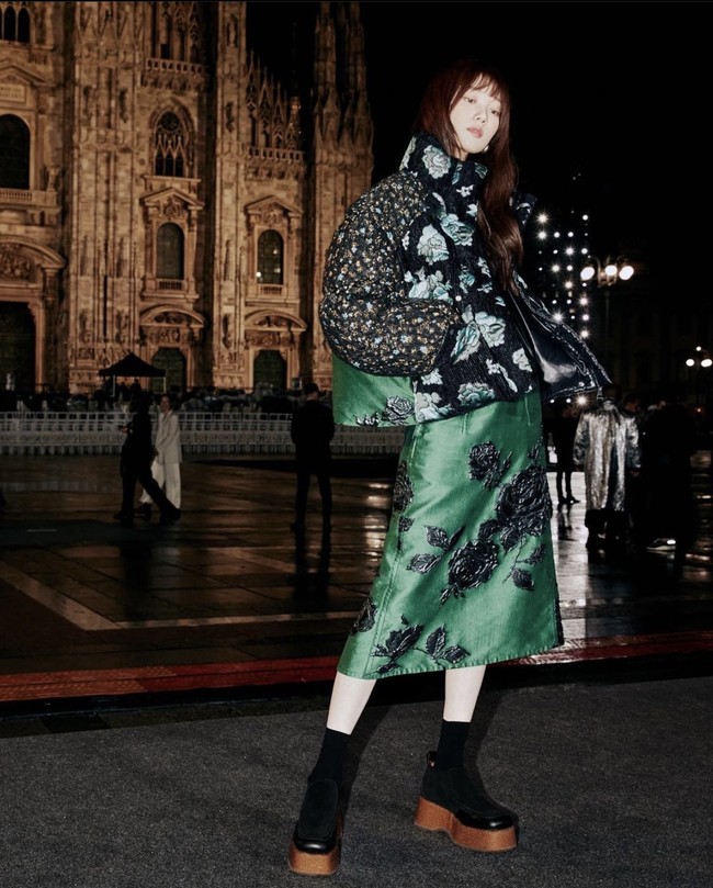Ada pula Lee Sung Kyung yang hadir di Milan Fashion Week sebagai brand ambassador Moncler. Mantan kekasih Nam Joo Hyuk itu terlihat edgy dalam balutan puff jacket bermotif bunga yang serasi dengan midi skirt dan platform boots-nya. Foto: Instagram