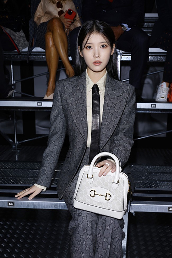 IU memulai debutnya di Milan Fashion Week sebagai brand ambassador Gucci. Pelantun Celebrity itu tampil edgy bak lady boss memakai setelan jas abu-abu. Penampilannya disempurnakan koleksi handbag putih Gucci dan heels hitam. Foto: Instagram