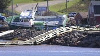 Sebuah perahu lobster terlihat terdampar di bebatuan di dermaga di Jembatan Stanley, Pulau Prince Edward. (AP/Brian McInnis)