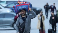 Warga Rusia membawa barang bawaannya saat melintasi perbatasan menuju Georgia. Sementara, Rusia belum menutup perbatasannya dan para penjaga umumnya tampak membiarkan orang-orang pergi.