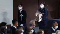 Istri Abe, Akie yang membawa abu mendiang suaminya ke lokasi pemakaman kenegaraan di Nippon Budokan Hall, Tokyo. Kim Kyung-Hoon/Pool Photo via AP.