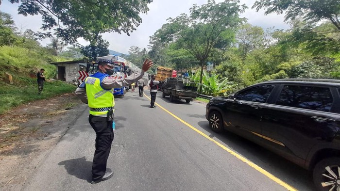 Petugas mengatur lalu lintas saat ada tronton terguling.