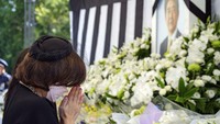 Warga datang dengan membawa bunga sebagai bentuk penghormatan terakhir.
