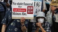 Warga Jepang yang menolak acara pemakaman ini pun mendatangi tempat pemakaman Shinzo Abe dengan membawa spanduk protes. (Takashi Aoyama/Getty Images)  