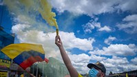 Seorang demonstran tampak menyalakan flare.