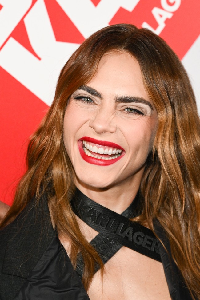 Inilah senyum lebar Cara di momen tersebut. Model 30 tahun itu tampil dengan lipstik merah. Foto: Corbis via Getty Images/Stephane Cardinale - Corbis