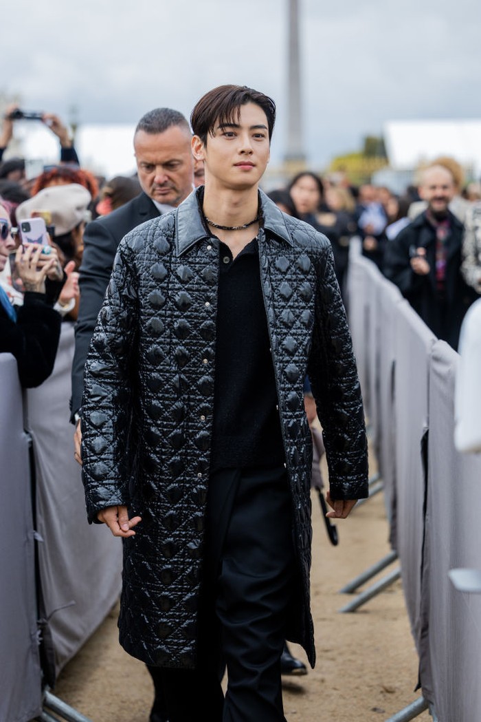 PARIS, FRANCE - SEPTEMBER 27: Cha Eun-woo wears black varnished coat, pants outside Dior during Paris Fashion Week - Womenswear Spring/Summer 2023 : Day Two on September 27, 2022 in Paris, France. (Photo by Christian Vierig/Getty Images)