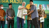 Komisaris Independen BSI M Arief Rosyid Hasan (kedua kanan) memberikan buku secara simbolis kepada Komisaris Utama BSI Adiwarman Azwar Karim (tengah) saat acara Syukuran Peluncuran Buku dan Diskusi Berjamaah untuk Indonesia Maju di Aula Buya Hamka, Masjid Agung Al Azhar, Jakarta (27/9).