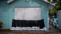 Mereka pun mengupayakan keamanan rumah hingga toko agar minim kerusakan akibat hantaman badai. (Ricardo Arduengo/AFP/Getty Images)  
