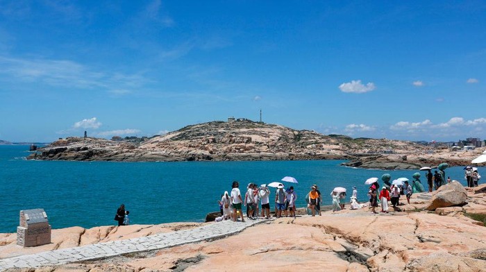 PINGTAN, CHINA - AUGUST 05: Tourists visit a scenic area on an island on August 5, 2022 in Pingtan County, Fuzhou City, Fujian Province of China. (Photo by VCG/VCG via Getty Images)