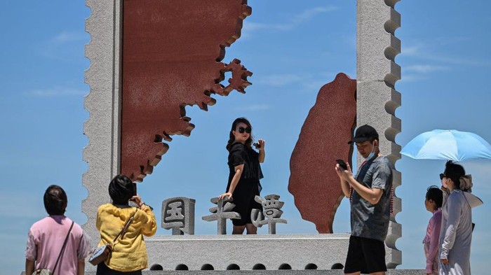 Tourists visit a scenic area on Pingtan island, one of mainland China's closest points to Taiwan, in Fujian province on August 6, 2022. (Photo by Hector RETAMAL / AFP) (Photo by HECTOR RETAMAL/AFP via Getty Images)