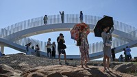 Di bawah terik matahari, turis nampak bersantai hingga berfoto di Pulau Pingtan. 