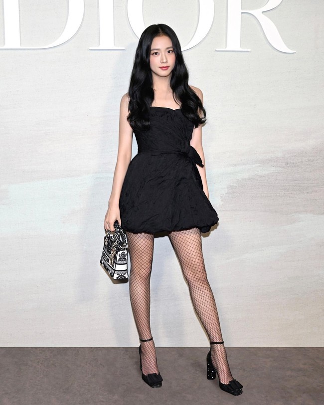 Jisoo BLACKPINK mewakili Dior di Paris Fashion Week sebagai global ambassador. Bintang drama Korea Snowdrop itu tampil anggun memakai mini dress hitam koleksi Dior Resort 2023 dengan stocking jaring. Penampilannya dilengkapi dengan heels mengkilap dan Dior Mini Lady D-Lite Bag. Foto: Instagram