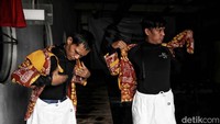 Tampak penyelam tengah mempersiapkan baju batik dalam peragaan busana bawah air.