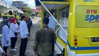 Presiden Jokowi didampingi Menteri Ketenagakerjaan Ida Fauziyah menyaksikan peserta penerima Bantuan Subsidi Upah (BSU) melakukan penarikan dana melalui ATM pada Mobil Kas Keliling (MKK) Bank BTN di Ternate, Maluku Utara, Selasa (27/9). 