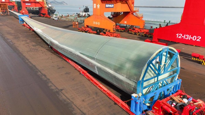 LIANYUNGANG, CHINA - SEPTEMBER 27: A 123-meter-long wind turbine blade is loaded onto a cargo ship at a port on September 27, 2022 in Lianyungang, Jiangsu Province of China. As the world's longest wind turbine blade, it will be transported to Yancheng for trial run. (Photo by VCG/VCG via Getty Images)