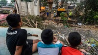 Anak-anak asyik menonton pengerjaan turap Kali Semanan.