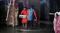 Salah satu penduduk menyelamatkan barang miliknya untuk dipindahkan ke tempat yang lebih aman. Ketinggian air di Sungai Yamuna melonjak melewati tanda evakuasi.