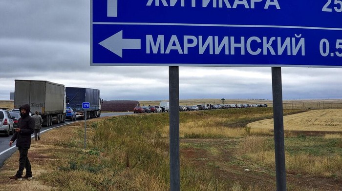 Tak Mau Dikirim ke Ukraina, Warga Rusia Kabur ke Kazakhstan People walk next to their cars queuing to cross the border into Kazakhstan at the Mariinsky border crossing, about 400 kilometers (250 miles) south of Chelyabinsk, Russia, Tuesday, Sept. 27, 2022. Officials say about 98,000 Russians have crossed into Kazakhstan in the week since President Vladimir Putin announced a partial mobilization of reservists to fight in Ukraine. (AP Photo)