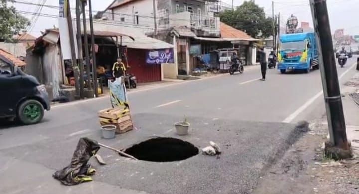 Jalan berlubang di Jl Raya Cibungbulang, Kabupaten Bogor.