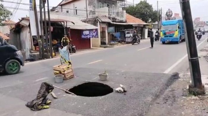 Jalan berlubang di Jl Raya Cibungbulang, Kabupaten Bogor.