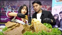 Penasaran dengan bakso segunung yang dipenuhi dengan isian tetelan dan daging melimpah. Pasangan muda ini tampak serius menghabiskan hidangan bakso jumbo milik mereka. Foto: Instagram Youtube