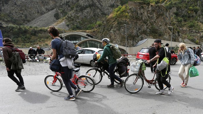 Travellers walk after crossing the border with Russia at the frontier checkpoint Verkhny Lars - Zemo Larsi, Georgia September 28, 2022. REUTERS/Irakli Gedenidze