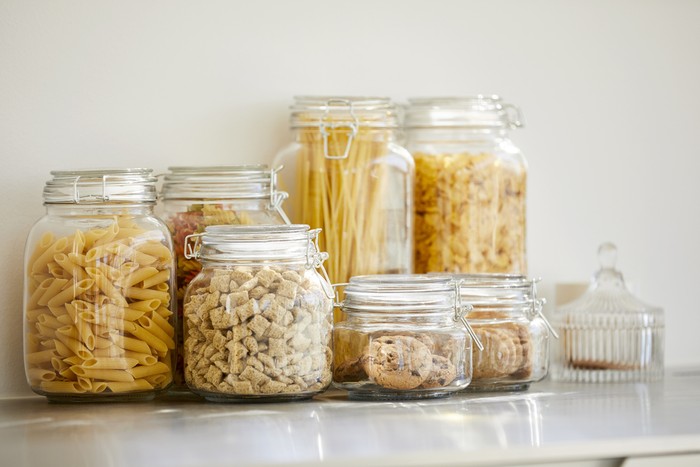 Close-up of food items in airtight jars. Fresh groceries are seen through glass containers. Eatables are on table.