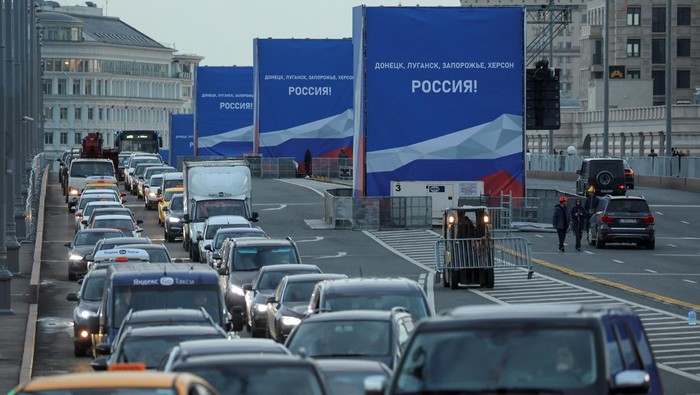 4 Wilayah Ukraina Gabung Rusia, Putin Siap Gelar 'Pesta' Seremoni Vehicles are stuck in a traffic jam near banners, set up ahead of an expected ceremony and concert to declare four Ukraine's self-proclaimed regions part of Russia following recent referendums, on a bridge in central Moscow, Russia September 29, 2022. A slogan on the banners reads: