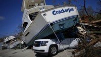 Sebuah perahu terdampar di atas sebuah mobil di Pantai Fort Myers, Florida, Amerika Serikat, Kamis (29/9/2022) waktu setempat. (AP Photo/Rebecca Blackwell)  