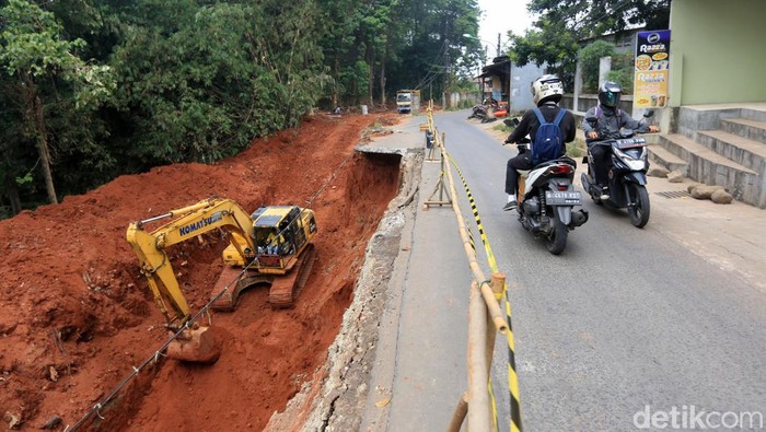 Jalan Pangkalan I Bantar Gebang Longsor Petugas dengan menggunakan alat berat melakukan proses pembaikan jalan yang longsor di Jalan Pangkalan 1, Bantar Gebang, Kota Bekasi, Jawa Barat, Jumat (30/9/2022). Rencananya jalan ini akan ditutup permanen selama proses pengerjaan perbaikan dilakukan. Proses perbaikan dilakukan awalnya dengan memasang turap penahan.