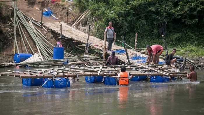 Jembatan Darurat di Bengawan Solo Rusak, Akses Warga Terputus Warga memindahkan jembatan darurat sesek bambu rusak yang menghubungkan Kampung Sangkrah, Pasar Kliwon, Solo dengan Desa Gadingan, Mojolaban, Sukoharjo, Jawa Tengah, Jumat (30/9/2022). Jembatan darurat yang dibuat secara swadaya masyarakat sebagai alternatif jalan untuk menyeberangi sungai Bengawan Solo tersebut putus akibat hujan dan terkena derasnya arus sungai. ANTARA FOTO/Mohammad Ayudha/foc.