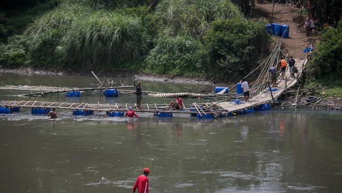Jembatan Darurat di Bengawan Solo Rusak, Akses Warga Terputus Warga memindahkan jembatan darurat sesek bambu rusak yang menghubungkan Kampung Sangkrah, Pasar Kliwon, Solo dengan Desa Gadingan, Mojolaban, Sukoharjo, Jawa Tengah, Jumat (30/9/2022). Jembatan darurat yang dibuat secara swadaya masyarakat sebagai alternatif jalan untuk menyeberangi sungai Bengawan Solo tersebut putus akibat hujan dan terkena derasnya arus sungai. ANTARA FOTO/Mohammad Ayudha/foc.