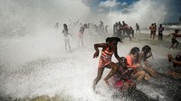 Anak-anak pun dengan senang hati bermain di pinggiran pantai dengan ombak besar.  