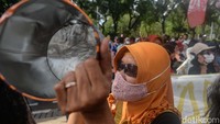 Puluhan emak-emak ini membawa panci dan kaleng biskuit saat berdemo di depan Balai Kota Jakarta.