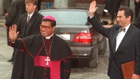 Uskup Belo (kiri) dan Jose Ramos-Horta melambai setibanya di balai kota Oslo untuk upacara penerima Nobel, Selasa (10/12/1996). Disebutkan laporan De Groene Amsterdammer bahwa dua pria yang mengklaim sebagai korban, menuturkan ketika remaja, berusia sekitar 14-16 tahun, mereka dilecehkan secara seksual oleh Belo di rumahnya di Dili dan kemudian diberi uang olehnya. (AP Photo/Jon Eeg)