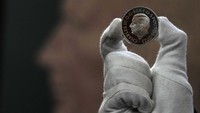 Seorang anggota staf dari Royal Mint menunjukkan uang koin bergambar Raja Charles III di London, Inggris, (29/9/2022).