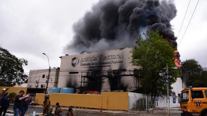Flames and smoke rise from a fire at the Superior Court of Electoral Justice (TSJE) headquarters in Asuncion on September 29, 2022. - A fire destroyed thousands of electronic ballot boxes in Paraguays Superior Tribunal of Electoral Justice, two months before the primary elections in which the candidates for the 2023 presidential elections will be defined, reported Thursday authorities who are also searching for two missing officials. (Photo by NORBERTO DUARTE / AFP)