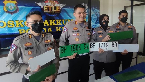Pelat nomor kendaraan berwarna hijau.