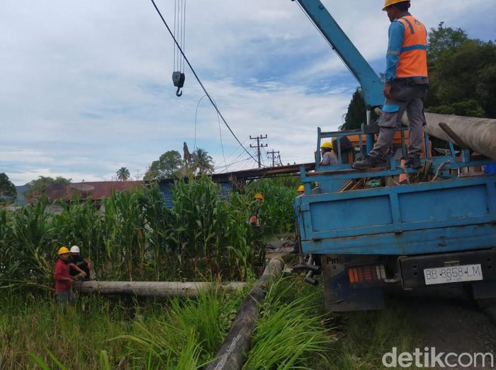 Petugas PLN memperbaiki jaringan listrik yang rusak akibat gempa di Tapanuli Utara.