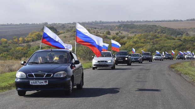 A motorcade with Russian national flags drive during celebrations marking the annexation of the Donetsk region into Russia in Donetsk, Ukraine, Friday, Sept. 30, 2022. The signing of the treaties making the four regions part of Russia follows the completion of the Kremlin-orchestrated 