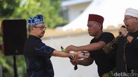 Pada pangkal alat ini, ada alas (dudukan) dari kayu yang diperkuat dengan lilitan pelat baja, agar tidak cepat terbelah jika dipukul. Nah, dalam permainan besi itu ditusukan ke bagian-bagian tubuh, bahkan di palu bagian pangkalnya, agar bisa menembus bagian-bagian tubuh yang ditusuk.