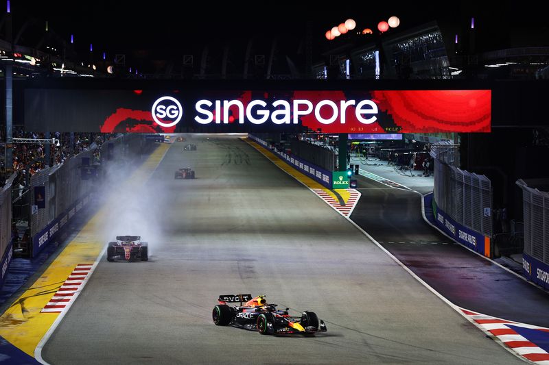 SINGAPORE, SINGAPORE - OCTOBER 02: Sergio Perez of Mexico driving the (11) Oracle Red Bull Racing RB18 leads Charles Leclerc of Monaco driving the (16) Ferrari F1-75 during the F1 Grand Prix of Singapore at Marina Bay Street Circuit on October 02, 2022 in Singapore, Singapore. (Photo by Clive Rose/Getty Images,)