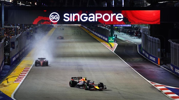 SINGAPORE, SINGAPORE - OCTOBER 02: Sergio Perez of Mexico driving the (11) Oracle Red Bull Racing RB18 leads Charles Leclerc of Monaco driving the (16) Ferrari F1-75 during the F1 Grand Prix of Singapore at Marina Bay Street Circuit on October 02, 2022 in Singapore, Singapore. (Photo by Clive Rose/Getty Images,)
