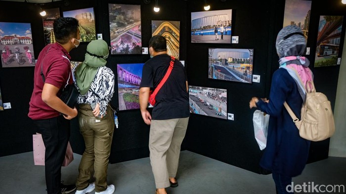 Pengunjung mengamati pameran foto Ruang Ketiga Jakarta di Taman Literasi Martha Christina Tialahu, Jakarta Selatan, Minggu (2/10/2022).