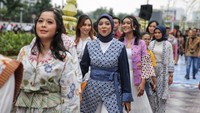 Sejumlah peserta melakukan catwalk dengan menggunakan baju batik di jalan Sudirman, Jakarta, Minggu (2/10/2022).   