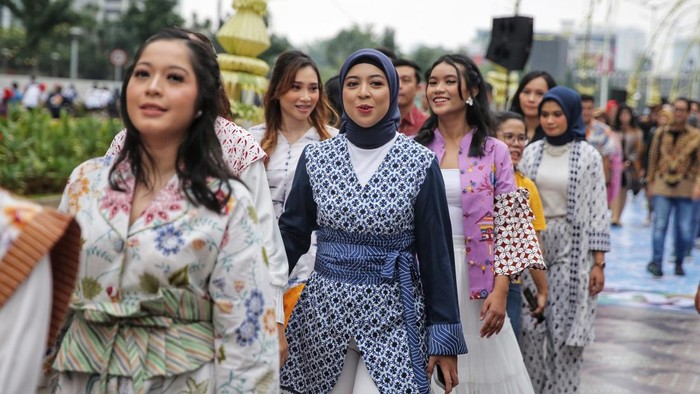 Sejumlah peserta melakukan catwalk dengan menggunakan baju batik di jalan Sudirman, Jakarta, Minggu (2/10/2022).