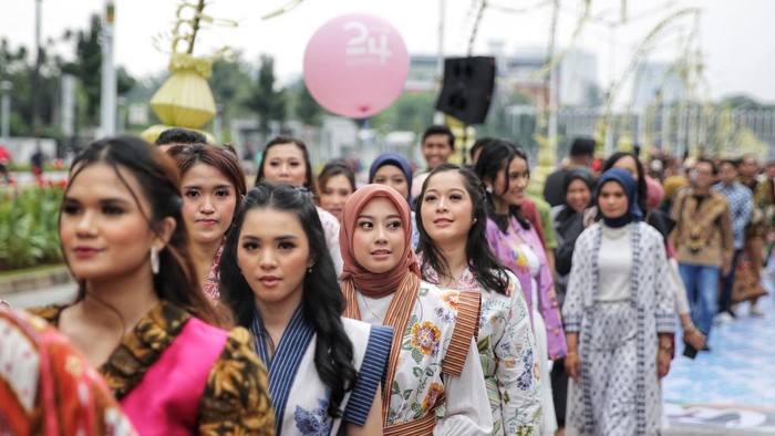 Sejumlah peserta melakukan catwalk dengan menggunakan baju batik di jalan Sudirman, Jakarta, Minggu (2/10/2022).