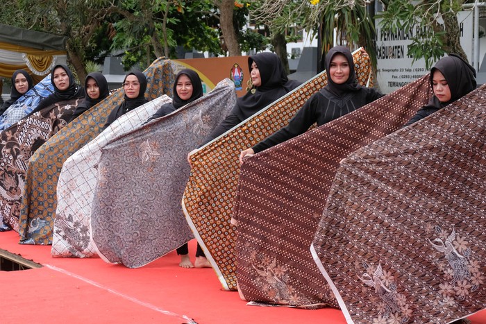 Peserta memamerkan kain batik saat peragaan busana batik pada peringatan Hari Batik Nasional di City Walk Kota Temanggung, Jawa Tengah, Minggu (2/10/2022). Sedikitnya 60 perajin dengan ratusan karya batik bermotif potensi lokal kabupaten Temanggung dipamerkan sebagai ajang mengenalkan dan mempromosikan batik Temanggungan ke pasar nasioanl maupun internasional. ANTARA FOTO/Anis Efizudin/foc.