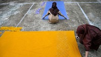 Dua orang siswi melakukan tahap penjemuran kain yang sudan selesi dibuat pola batik. 
